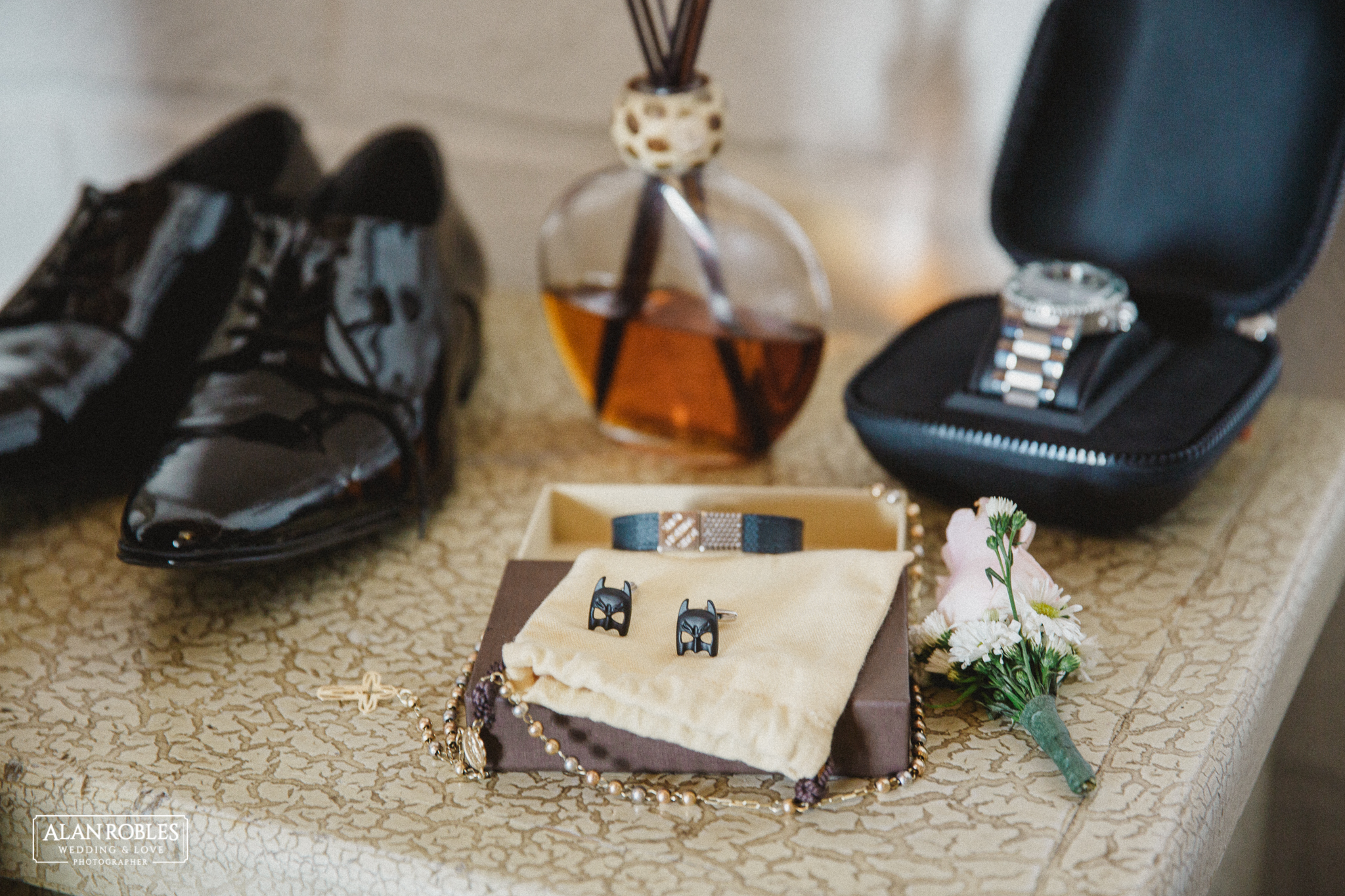 Detalle de los accesorios del novio, botonier, azar, mancuernillas de super heroe batman, zapatos y reloj para la boda. Fotografo de Bodas Alan Robles en Guadalajara.