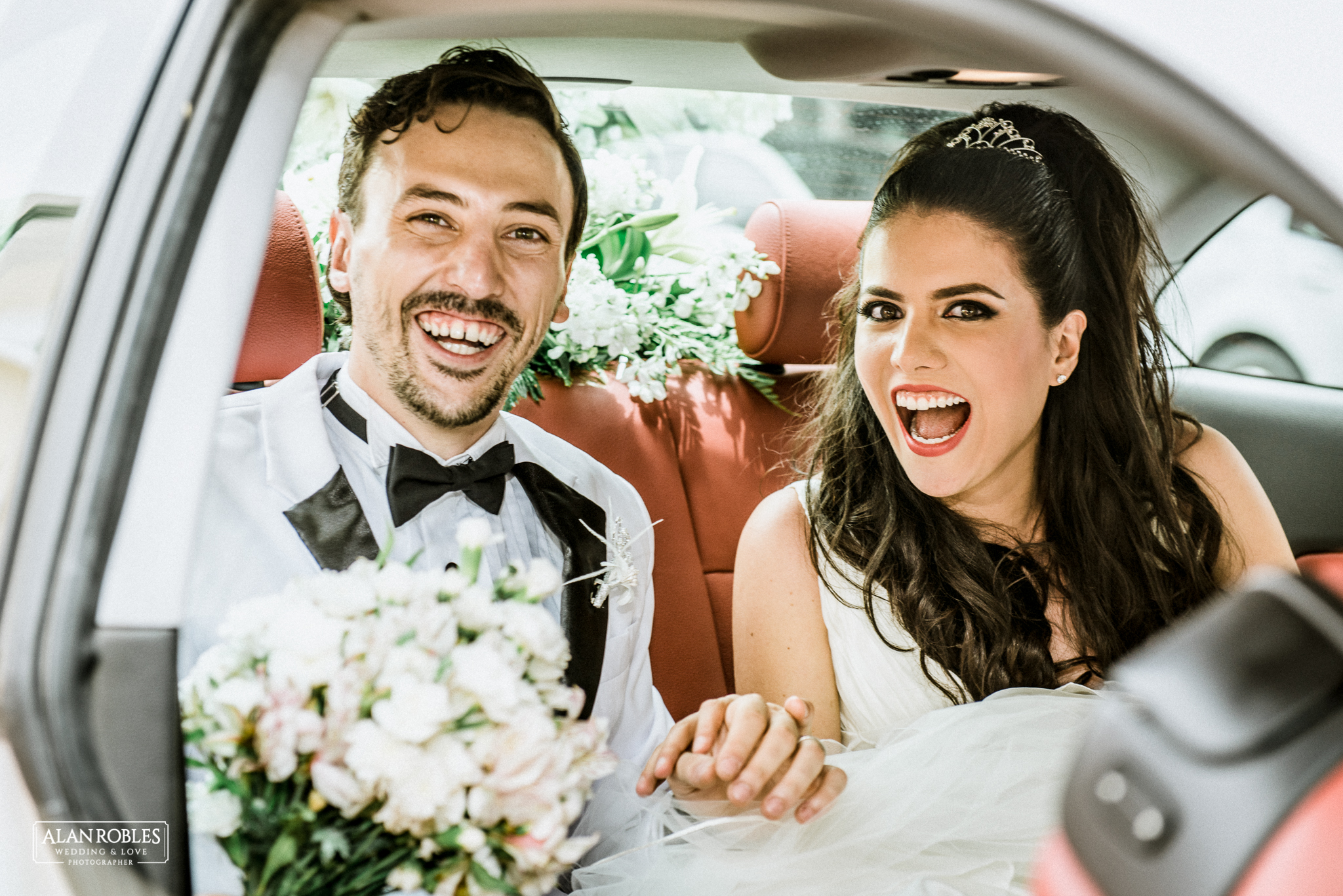 Novios sonriendo dentro del coche de bodas. Fotografia de bodas. Fotografo Alan Robles. Los mejores momentos de boda.